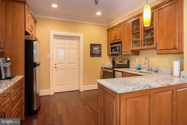a kitchen with a refrigerator a sink and wooden cabinets