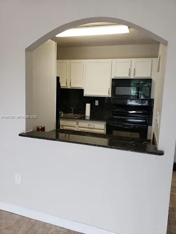 a view of living room with stainless steel appliances and cabinets