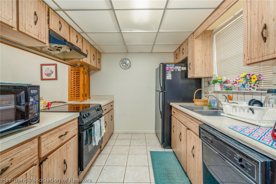 4722 Granada Boulevard Sebring, FL 33872 - Photo 3 of 11 a kitchen with stainless steel appliances granite countertop a sink stove and refrigerator