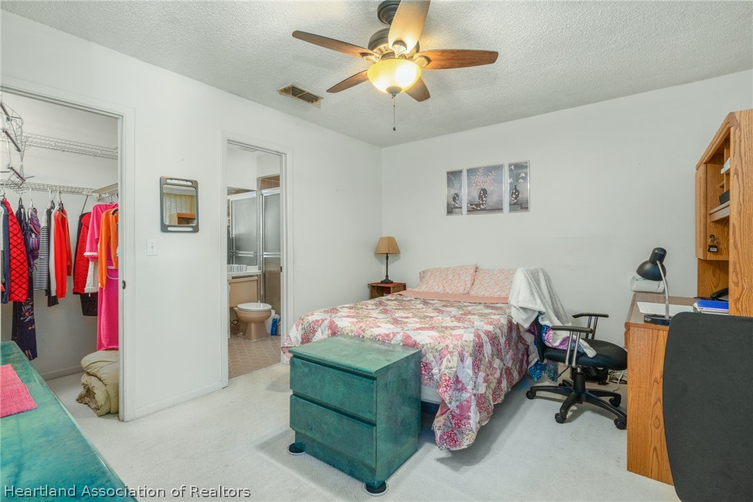 4722 Granada Boulevard Sebring, FL 33872 - Photo 6 of 11 a bedroom with a bed and a chandelier