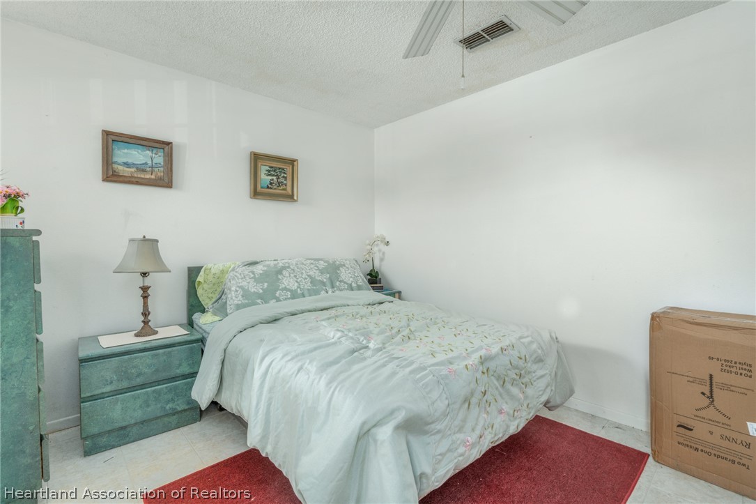 4722 Granada Boulevard Sebring, FL 33872 - Photo 7 of 11 a bedroom with a bed and a mirror