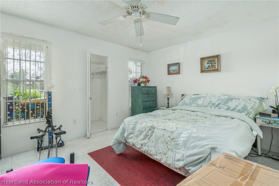 4722 Granada Boulevard Sebring, FL 33872 - Photo 8 of 11 a bedroom with a bed and a chandelier