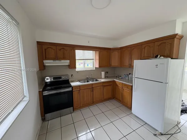 a kitchen with a refrigerator and a stove top oven