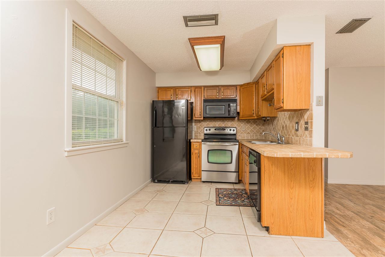 233 Cornell Road St. Augustine, FL 32086 - Photo 8 of 35 a kitchen with a refrigerator a stove top oven and cabinets