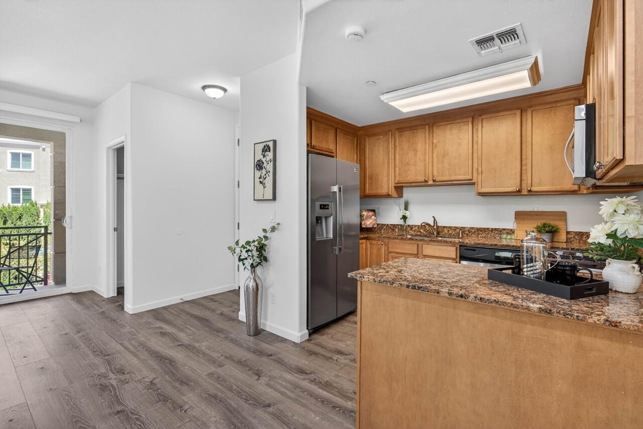 4712 Norris Canyon Road, Unit 104 San Ramon, CA 94583 - Photo 7 of 22 a kitchen with granite countertop a refrigerator and a sink