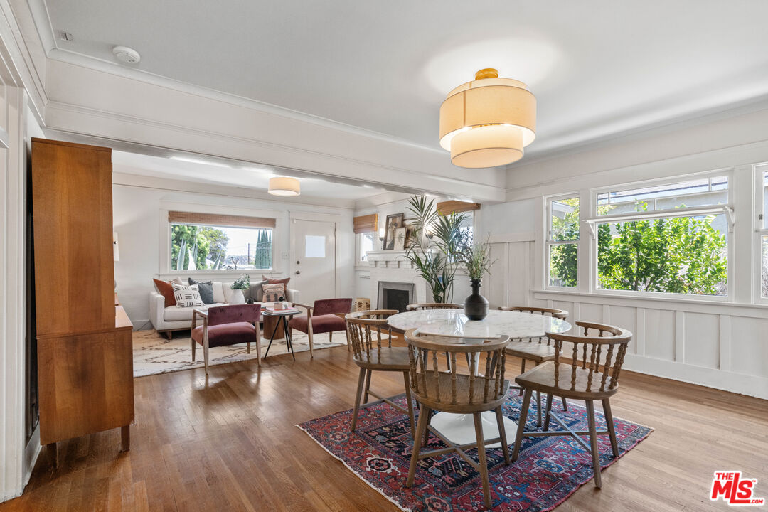 6157 Springvale Drive Los Angeles, CA 90042 - Photo 7 of 21 a dining room with wooden floor a chandelier a glass table and chairs