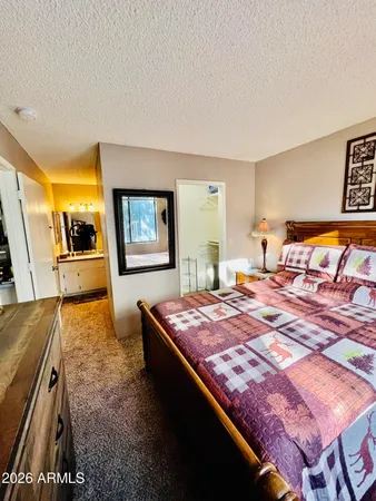 a bedroom with a bed and dresser with mirror