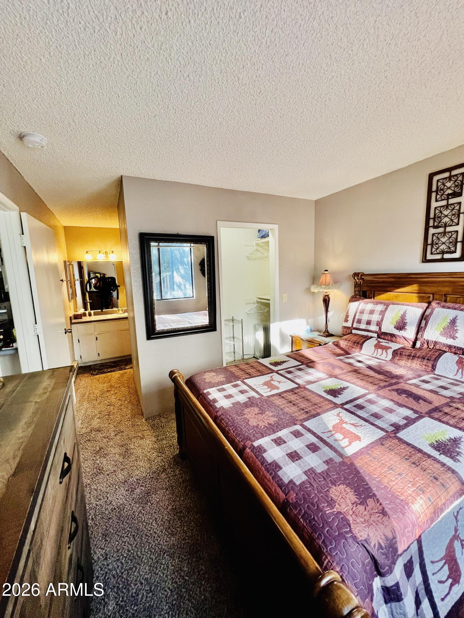 2700 South White Mountain Road, Unit 1126 Show Low, AZ 85901 - Photo 14 of 32 a bedroom with a bed and dresser with mirror