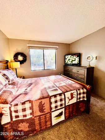 a bedroom with a bed lamp closet and window