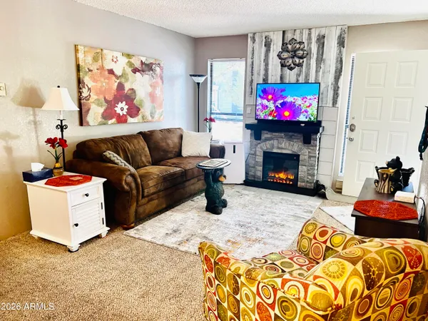 a living room with furniture a fireplace and a flat screen tv