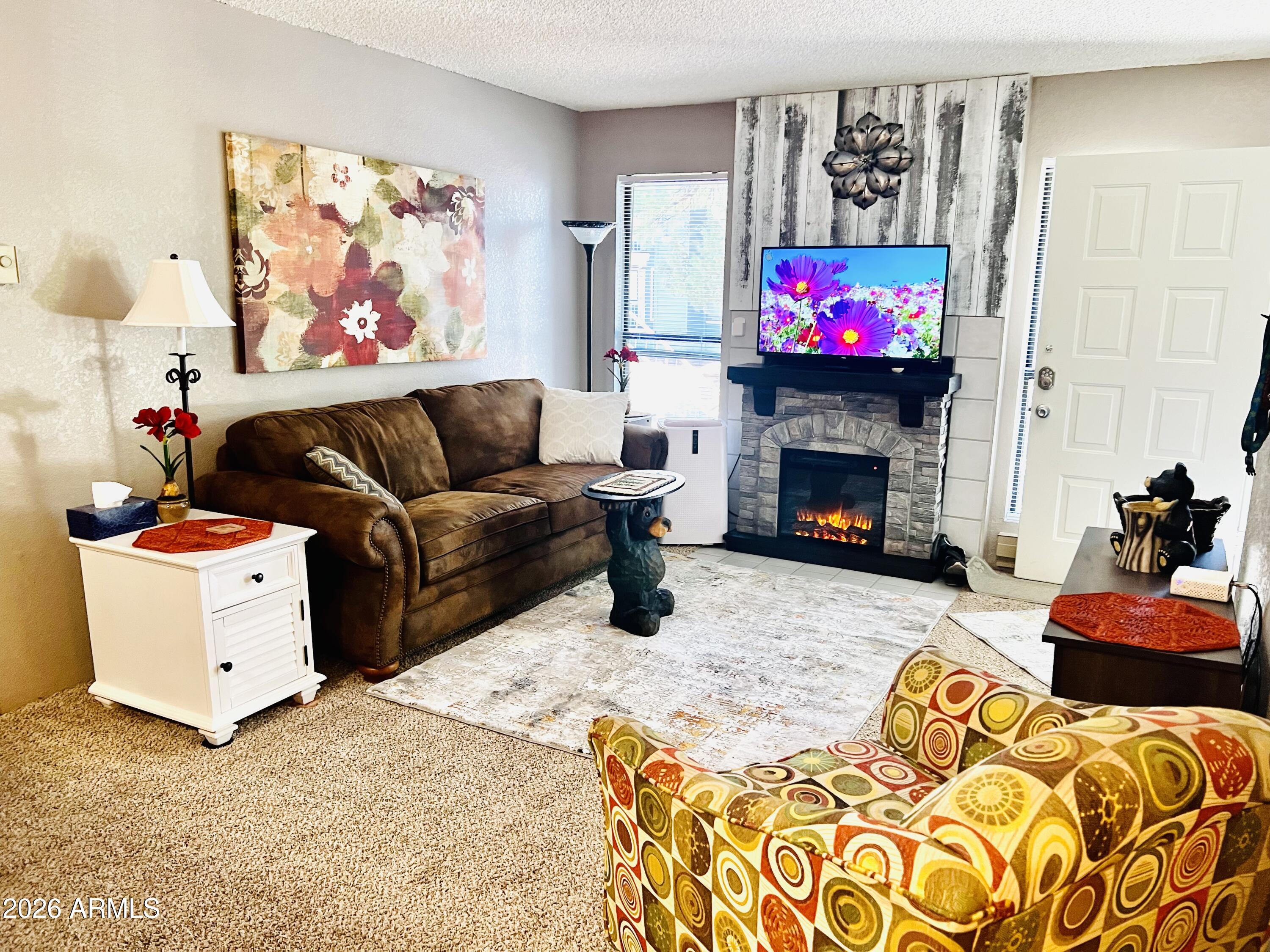 2700 South White Mountain Road, Unit 1126 Show Low, AZ 85901 - Photo 2 of 32 a living room with furniture a fireplace and a flat screen tv