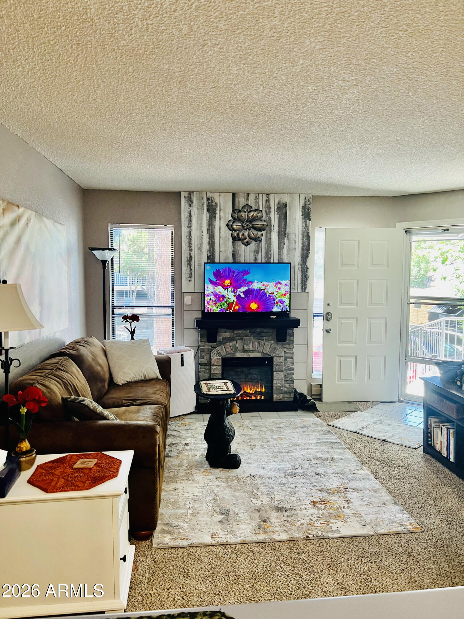 2700 South White Mountain Road, Unit 1126 Show Low, AZ 85901 - Photo 4 of 32 a living room with furniture a flat screen tv and a fireplace