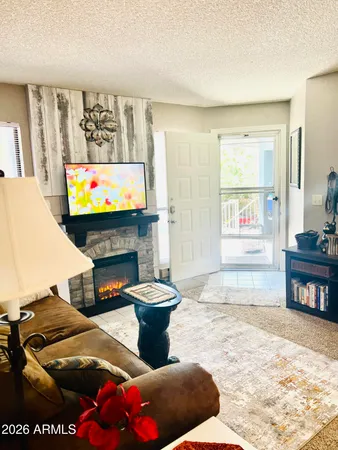 a living room with furniture a flat screen tv and a fireplace