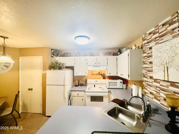 a kitchen with appliances a refrigerator and a stove top oven
