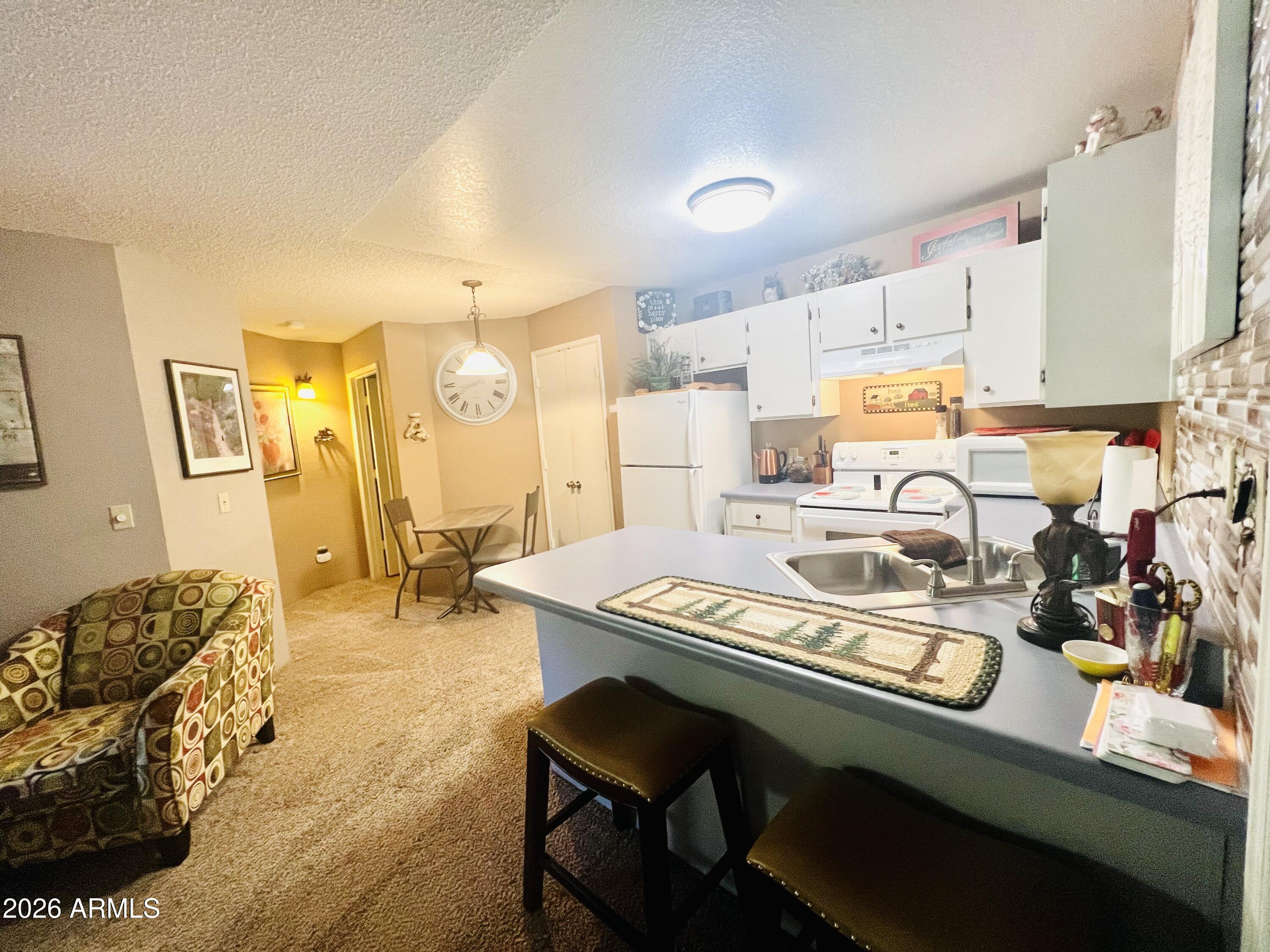 2700 South White Mountain Road, Unit 1126 Show Low, AZ 85901 - Photo 9 of 32 a kitchen with a sink cabinets and stove top oven