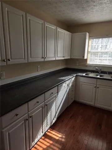 a kitchen with granite countertop white cabinets and white appliances