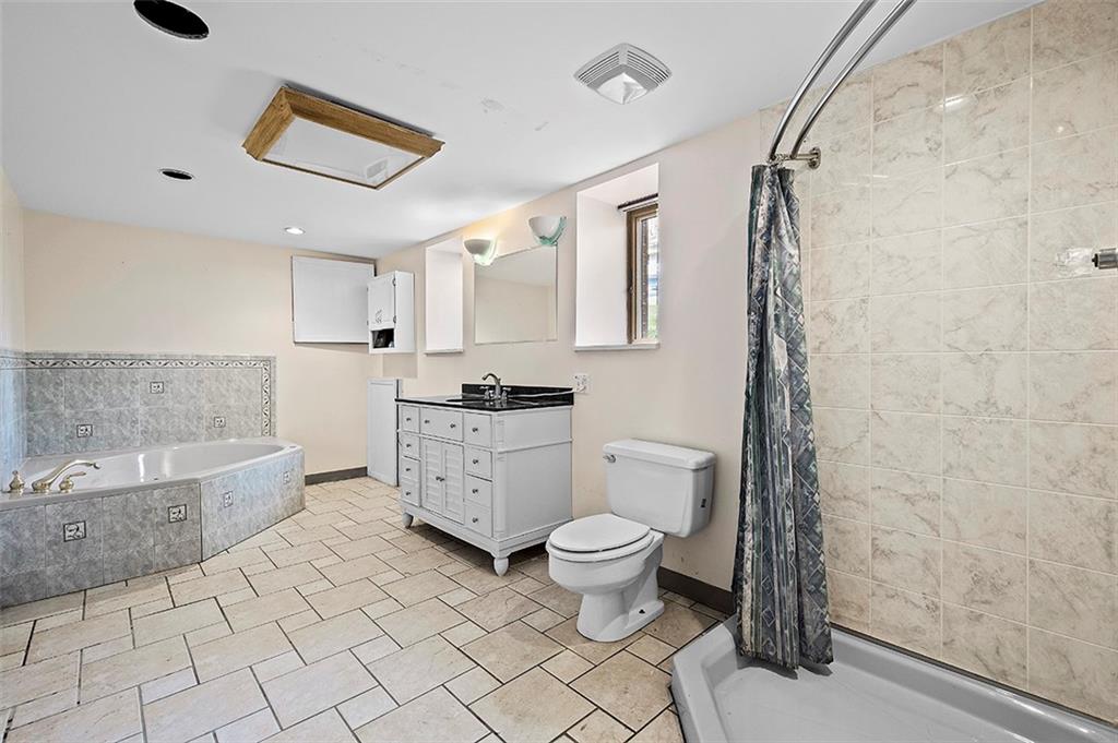 801 Elm Spring Road Pittsburgh, PA 15243 - Photo 19 of 25 a large white bathroom with a granite countertop sink a toilet a mirror and bathtub