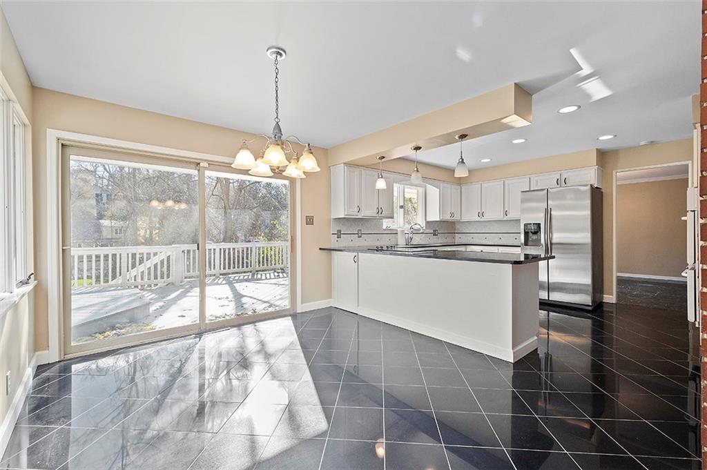 801 Elm Spring Road Pittsburgh, PA 15243 - Photo 6 of 25 a kitchen with stainless steel appliances granite countertop a stove a sink a refrigerator with white cabinets and wooden floor