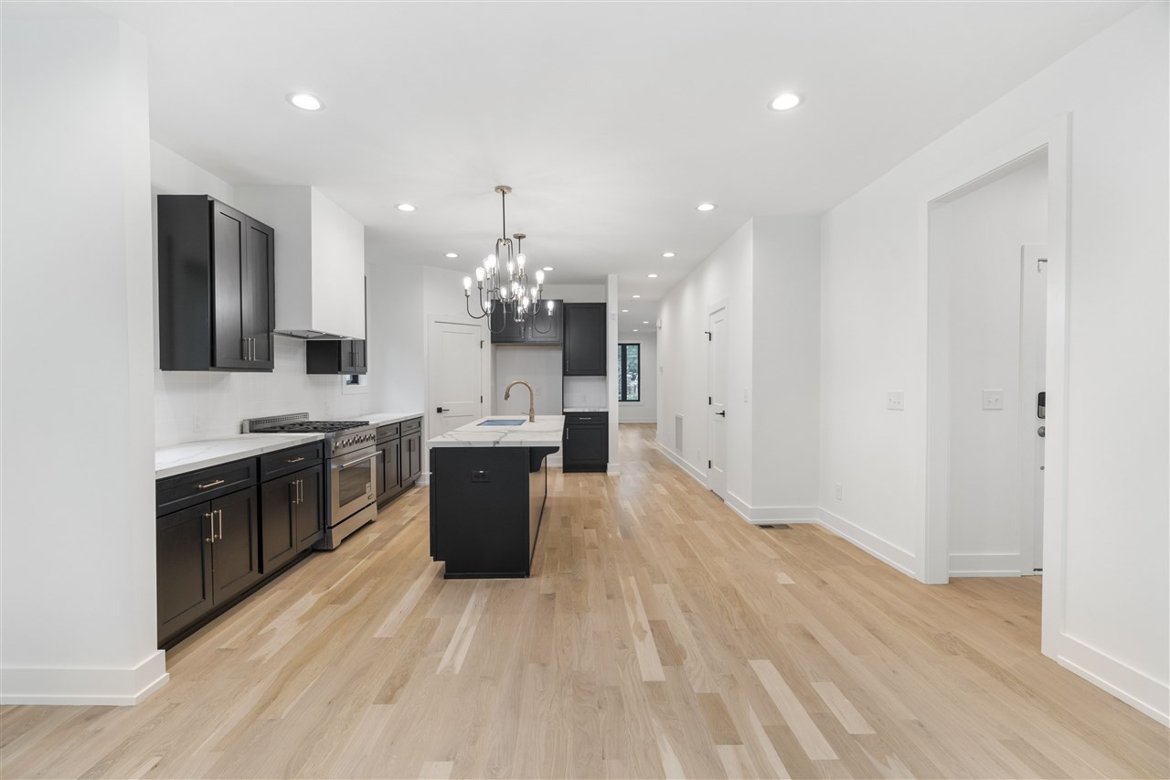 1600 Glendale Avenue Durham, NC 27701 - Photo 10 of 29 a large kitchen with a sink and dishwasher a stove top oven with wooden floor