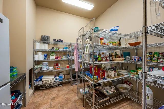 a view of a backyard with couches table and chairs under an umbrella with a tub