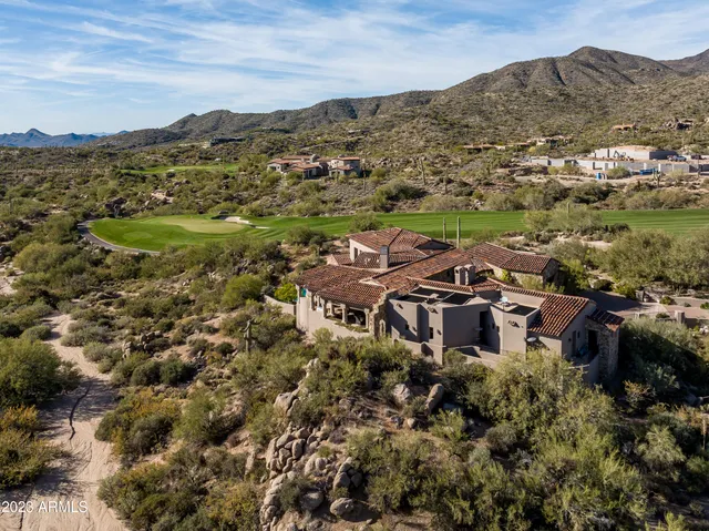 a front view of a house with plants and trees