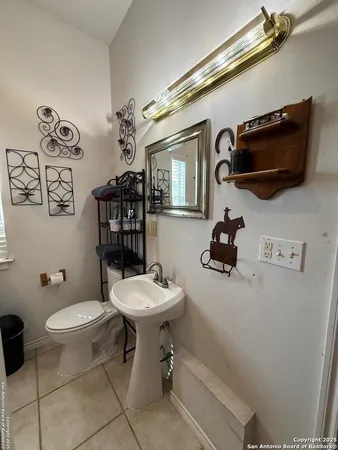 a bathroom with a toilet a sink and mirror