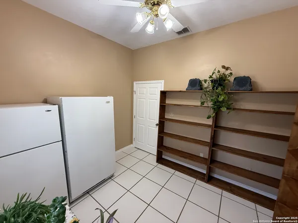 a view of storage and utility room with closet and window