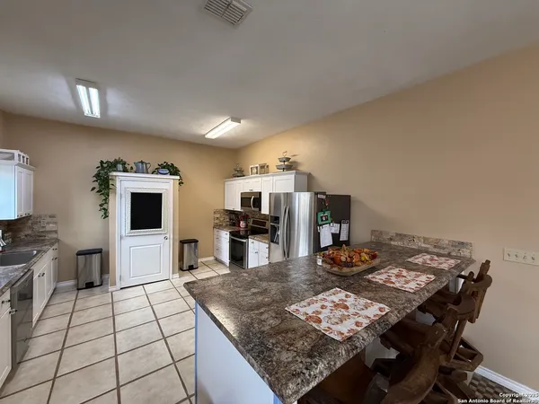 a large kitchen with a table and chairs in it