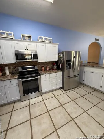 a kitchen with granite countertop a stove a sink and a microwave