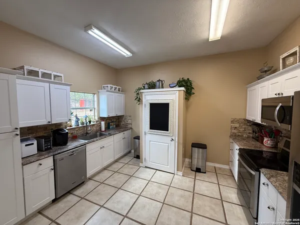 a kitchen with stainless steel appliances a stove a sink and a microwave