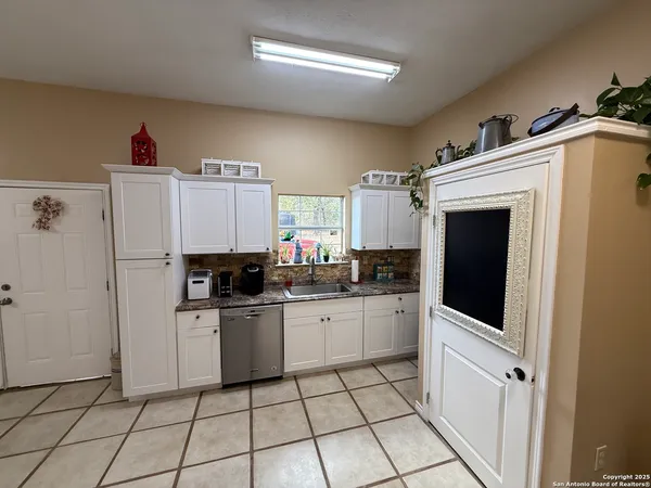 a kitchen with white cabinets a sink and white appliances