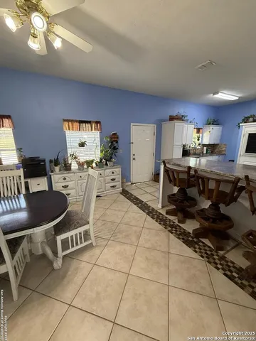 a living room with furniture a flat screen tv and kitchen view