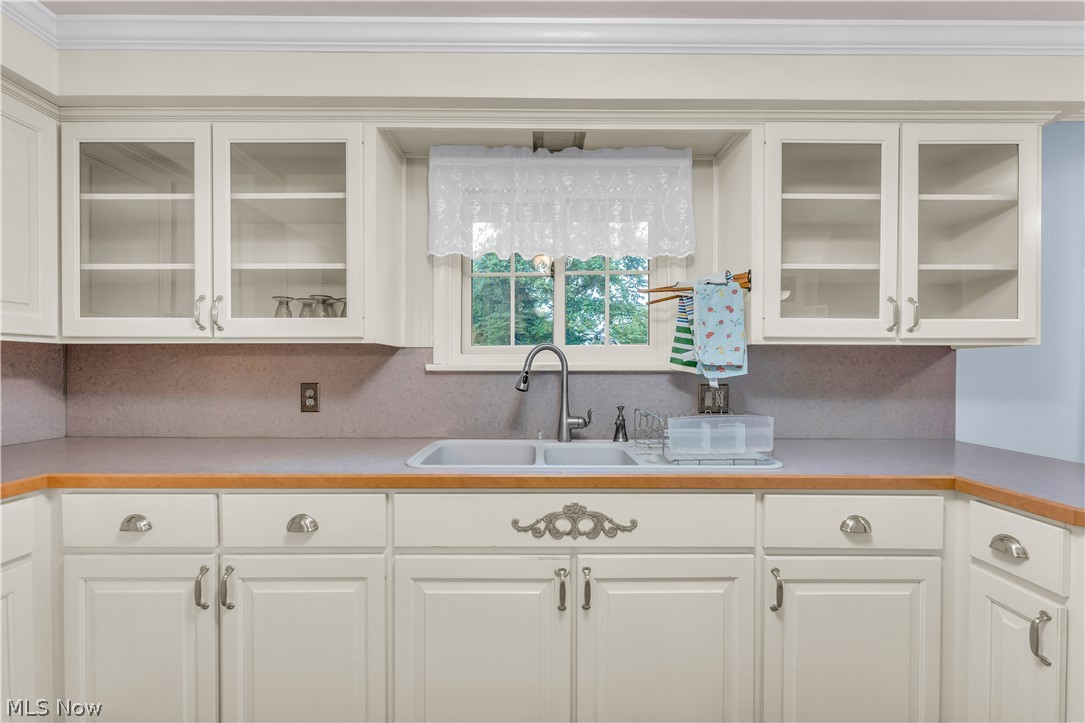 9897 West Ridge Road Elyria, OH 44035 - Photo 16 of 43 Kitchen featuring sink, white cabinets, and ornamental molding