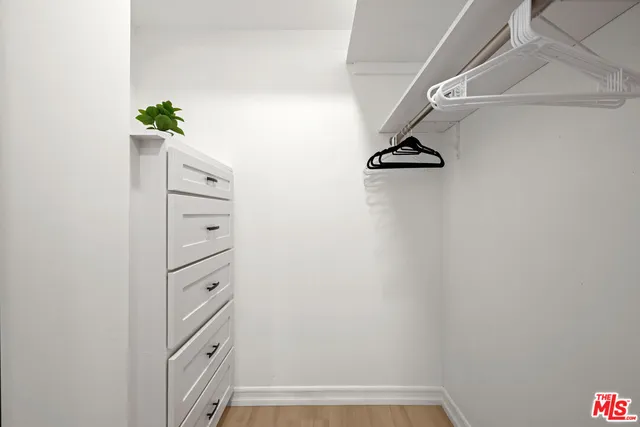 a view of walk in closet with clothes