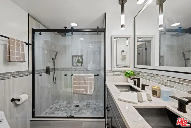 a bathroom with a granite countertop sink mirror vanity and shower