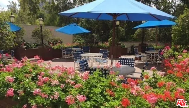 a view of a wooden house with a small yard and large trees