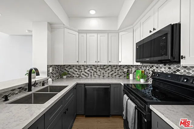 a kitchen with granite countertop a sink stove and microwave