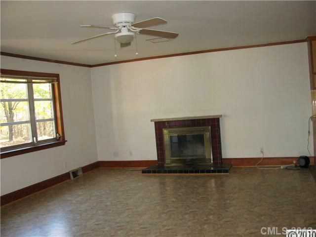 3902 Watson Church Road Monroe, NC 28110 - Photo 6 of 13 an empty room with a fireplace and fan