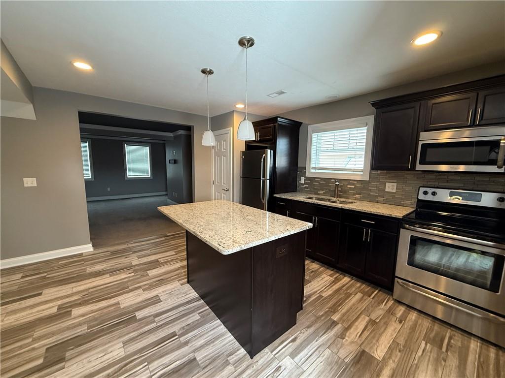 1312 Market Street, Unit 1 Beaver, PA 15009 - Photo 2 of 17 a kitchen with stainless steel appliances kitchen island granite countertop a stove a sink and a refrigerator