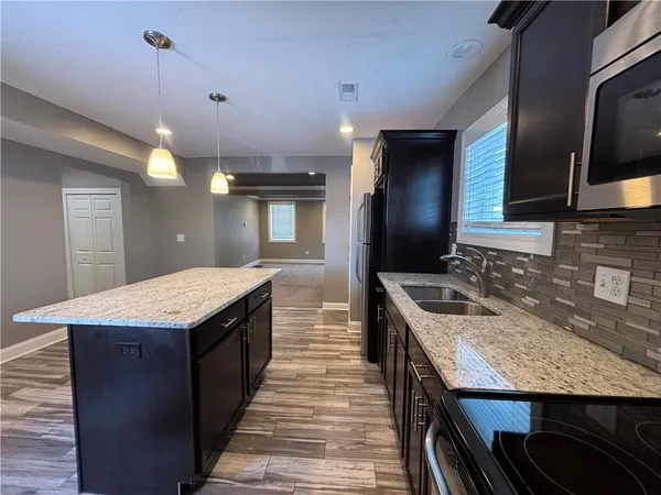 a kitchen with a stove and a wooden floor