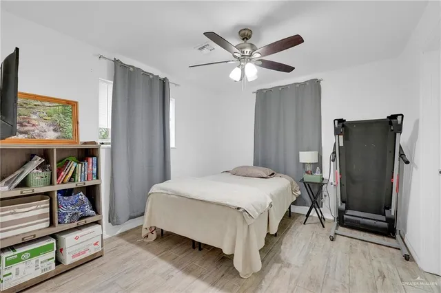 a bedroom with a bed a book shelf and a window