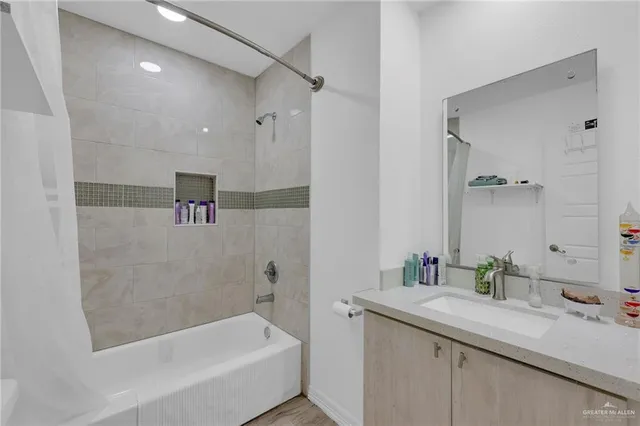 a bathroom with a granite countertop sink a toilet a mirror and shower