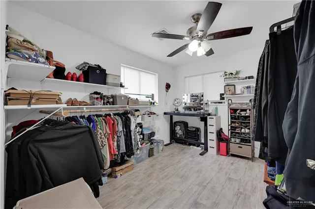 a view of walk in closet with clothes and shoes