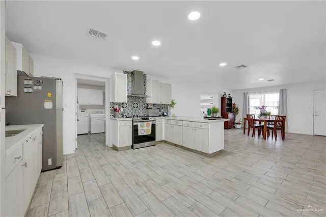 a kitchen with white cabinets and stainless steel appliances