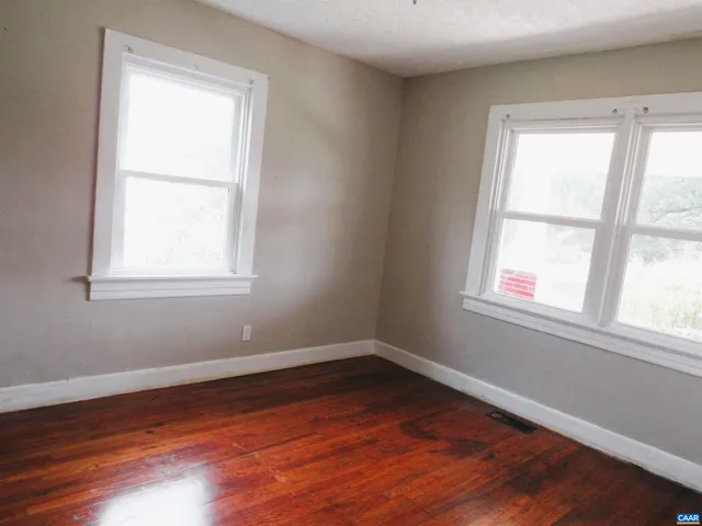a view of a room with wooden floor and windows in it
