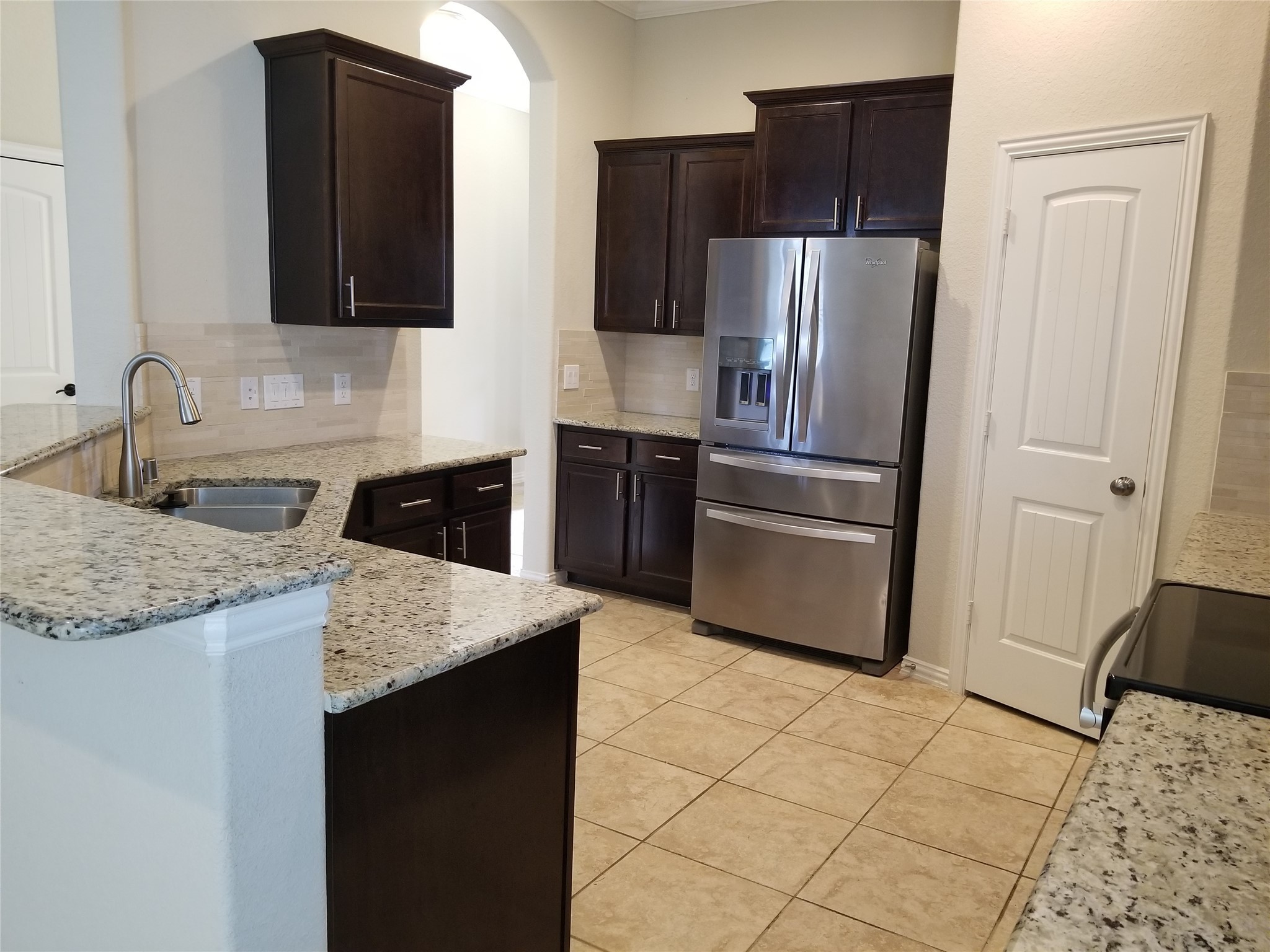 5217 Green Heath Lane Rosharon, TX 77583 - Photo 6 of 18 a kitchen with granite countertop a refrigerator and a stove top oven
