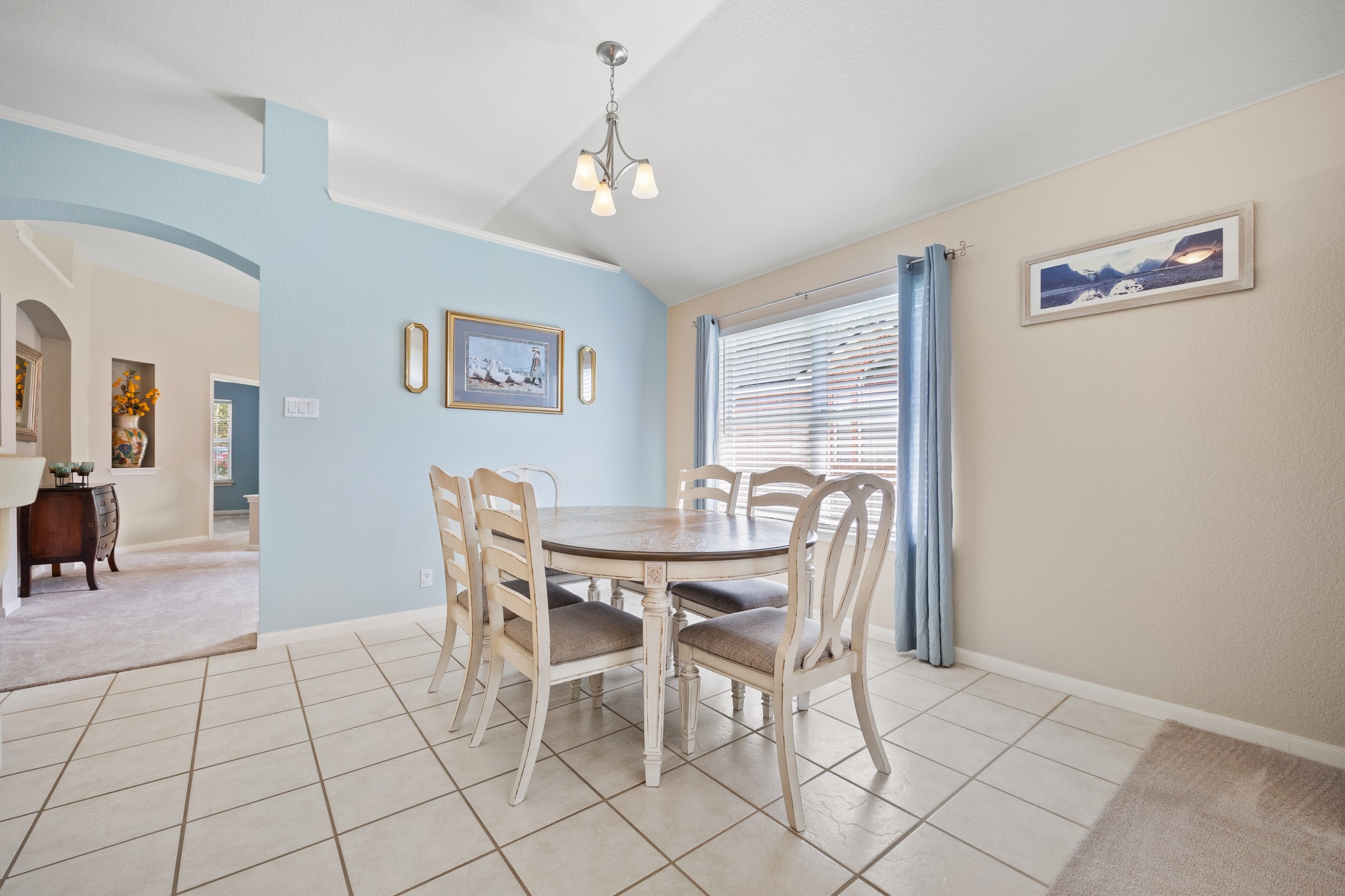 1108 Springbrook Road Pflugerville, TX 78660 - Photo 11 of 37 A refined dining space with tiled flooring, illuminated by a contemporary chandelier and natural light.