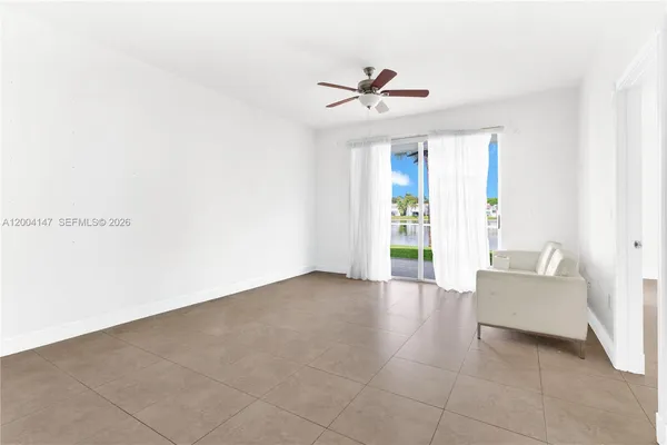 a living room with furniture and a ceiling fan