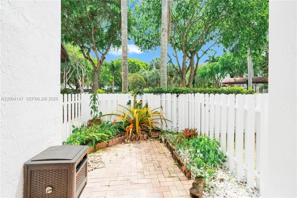 a view of a swimming pool with a lawn chairs under palm trees