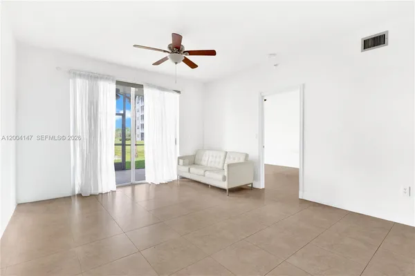 a view of kitchen with stainless steel appliances granite countertop white cabinets and wooden floor